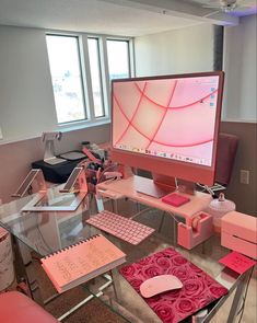 a desk with a computer monitor, keyboard and mouse on it in front of a window