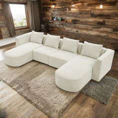 a large white sectional couch sitting on top of a rug in front of a window