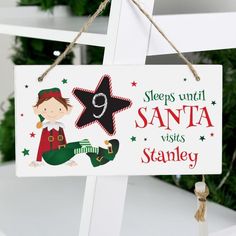 a wooden sign hanging from the side of a white chair next to a christmas tree