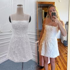 a woman taking a selfie in front of a dress on a mannequin