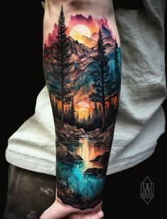 a man's arm with an image of mountains and trees in the water on it