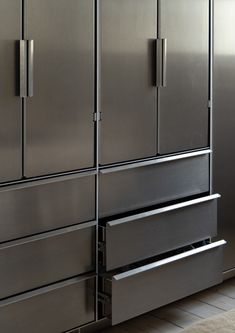 a large stainless steel refrigerator freezer sitting next to a kitchen counter top with drawers