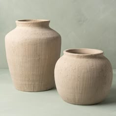 two large vases sitting next to each other on a table