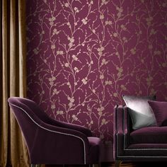 a purple couch and chair in front of a wallpapered room with gold flowers