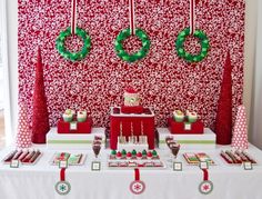 a table topped with cake and desserts under christmas decorations