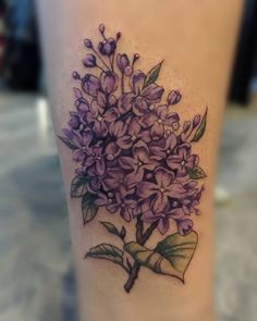 a tattoo with purple flowers on the leg