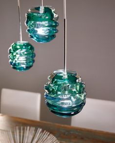 two green blown glass hanging lights over a dining room table