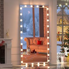 a living room filled with furniture and a christmas tree in front of a large mirror