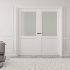 an empty room with two chairs and white walls