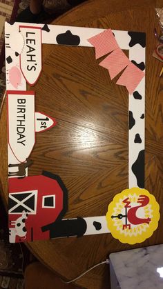 a wooden table topped with paper cutouts and cow print on the top of it