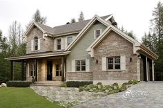 a large stone house in the middle of a wooded area