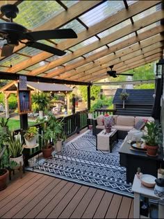 an outdoor living area with patio furniture and plants on the deck, surrounded by greenery