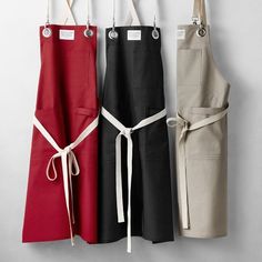 three aprons hanging up on the wall