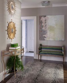 a living room with a rug, chair and painting on the wall