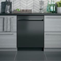 a black dishwasher sitting in the middle of a kitchen