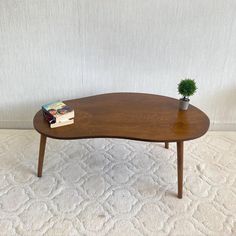 a wooden coffee table with a book on it and a potted plant sitting on top