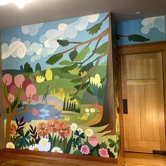 a painting on the side of a wall in a room with wood floors and wooden doors