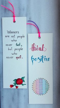 two bookmarks with words on them hanging from strings, one says winners are not people who fail but people who quit never quit