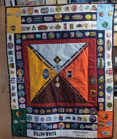 a quilt made to look like it has many different patches on it and is hanging from the wall