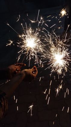 two people holding sparklers in their hands