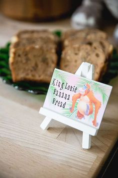 a wooden table topped with slices of bread and a sign that says king kong banana bread