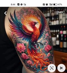 a colorful bird tattoo on the back of a woman's left arm and shoulder