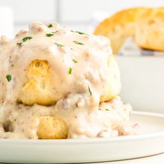 biscuits and gravy on a plate with bread in the background