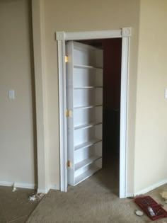 an empty room with the door open and tools scattered on the floor next to it