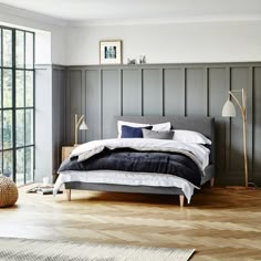 a bedroom with wood floors and gray walls