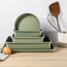 green dishes and utensils are on the counter