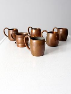 a row of coffee cups sitting on top of a white counter