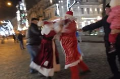 people dressed as santa clause dancing on the street