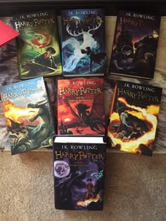 a collection of harry potter books on the floor