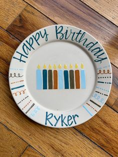 a birthday plate with candles on it that says happy birthday to the ryker