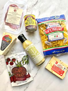 the ingredients to make this pasta dish are laid out on a marble counter top,