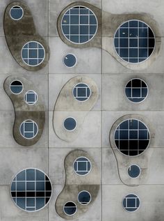 several different shapes and sizes of windows on a cement wall with squares in them,