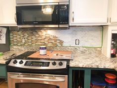 a stove top oven sitting inside of a kitchen next to a microwave and toaster oven