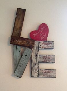 a cross and two hearts are hanging on the wall next to some wood planks