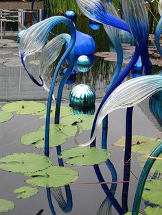 an abstract image with blue and green shapes in the middle, surrounded by water lilies