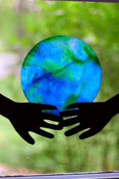 two hands reaching out to each other over a blue and green globe with the words, in the beginning god created 37 creation crafts & activities