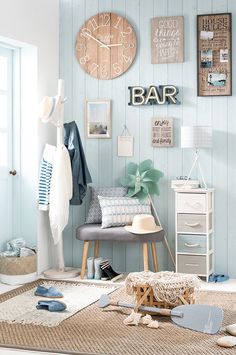 a living room with blue walls and pictures on the wall, including clothes hanging up