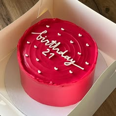 a red birthday cake in a box on a table