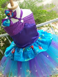 Cute design, sequin purple trim, blue ruffled bottom  ariel " out of print fabric "  please note I may NOT HAVE THE SAME EXACT FABRIC ANYMORE  WILL BE ANOTHER BLUE MATCHING Mermaid PRINT FABRIC USEDig cannot get this rare find...on corset top, laces on backside....rhinestone accents,  purple  teal and turquoise blue tutu skirt ( elastic waist) rhinestones accents on tutu skirt scattered about....  matching bow with rhinestone detail, limited edition,ariel fabric will differ than one shown will be similar please do allow 3  to 4 weeks to complete if need sooner please send me your need by date. I can change the color scheme if you like, the sequin trim or tulle fabric...all my tutus are sewn no knot ties:) Mermaid Corset Top, Mermaid Corset, Dress Up Storage, Ariel Costumes, Blue Tutu, Little Mermaid Ariel, Mermaid Theme Party, Mermaid Parties, Mermaid Print