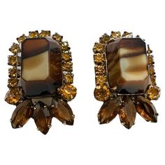 Introduce a touch of vintage glamour to your ensemble with these Vintage Marble Brown Glass and Champagne Color Rhinestone Clip-On Earrings. This exquisite pair combines the rich tones of marble brown glass with the subtle sparkle of champagne-colored rhinestones for a timeless and sophisticated look. Measuring at 1.20 inches in length and 0.77 inches in width, these clip-on earrings strike the perfect balance between statement and subtlety. The marble brown glass adds an element of depth and wa Ancient Egypt Fashion, American Art Deco, Egypt Fashion, Glass Champagne, Glamour Vintage, Brown Jewelry, Color Champagne, The Marble, Champagne Color