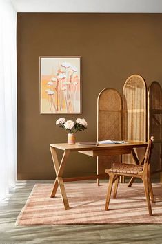 a dining room table and chairs in front of a brown wall with flowers on it