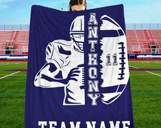 a woman is holding up a towel with an image of a football player on it