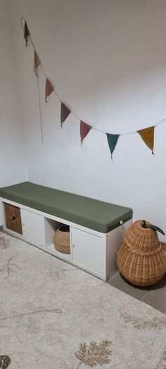 a room with a bed, table and baskets on the floor