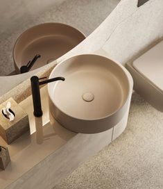 a bathroom sink sitting on top of a counter next to a toilet paper dispenser