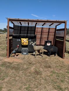 an outhouse with fake animals in it and other things on the ground around it