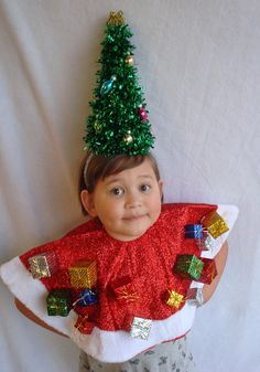 a little boy wearing a christmas tree hat